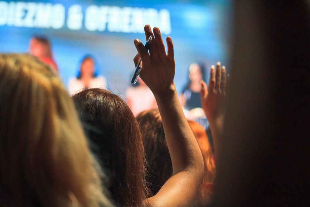 Hands raised in a crowd at an event or conference