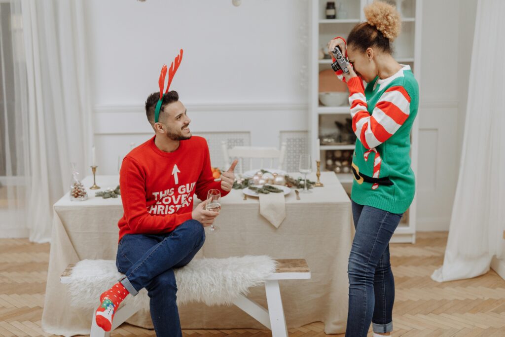 a man smiling at camera with christmas party props