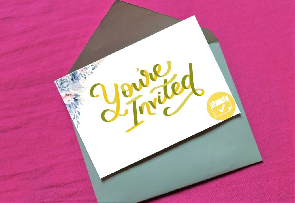 Envelope on pink background with invitation with 'you're invited' written on front.