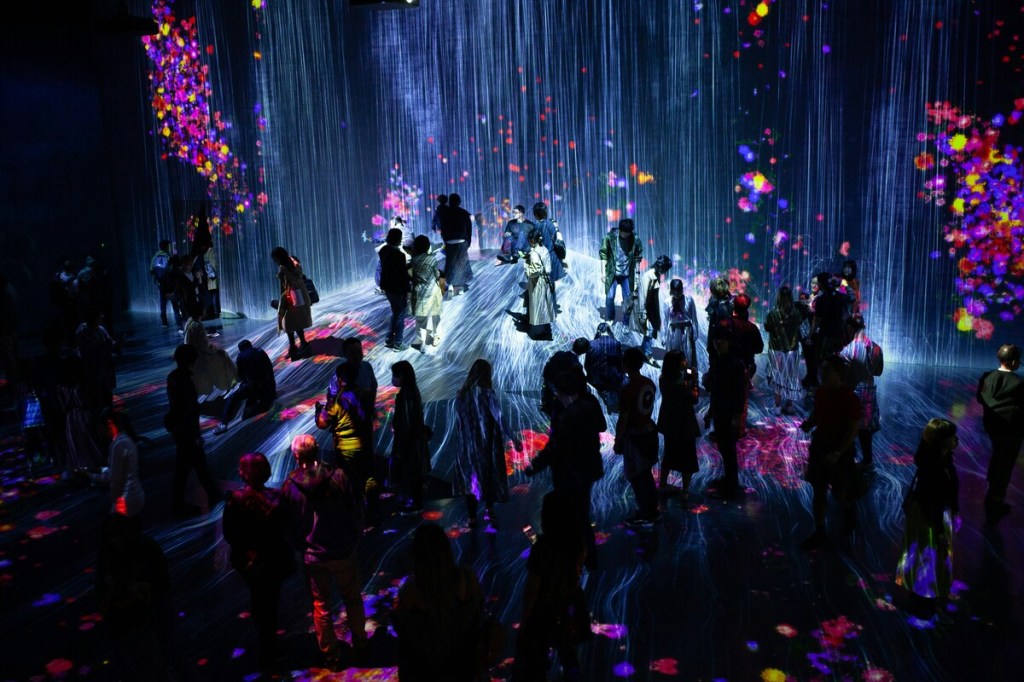 a group of people inside a room with projection mapping activations