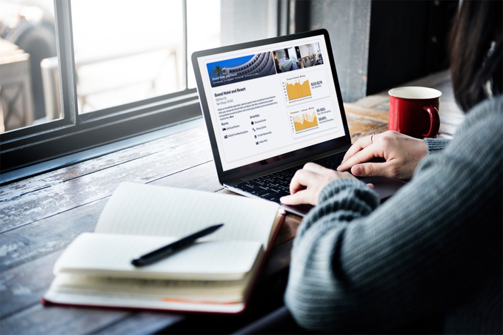 A meeting planner sits in front of a computer to arrange a group booking through an online, instant booking platform.