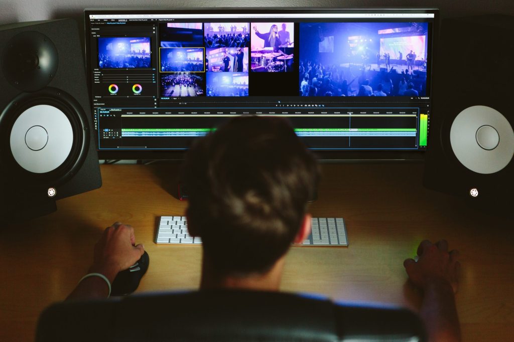 Man behind computer directing a video