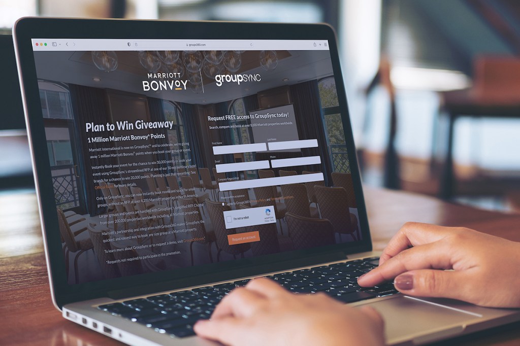 An image of a meeting planner's hands typing on a keyboard, with the screen showing the registration page for GroupSync and Marriott's instant booking platform for meetings.