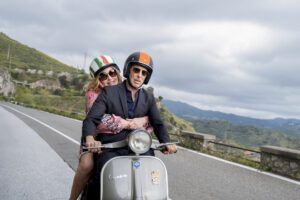 Jennifer Coolidge and Jon Gries of The White Lotus on a Vespa.