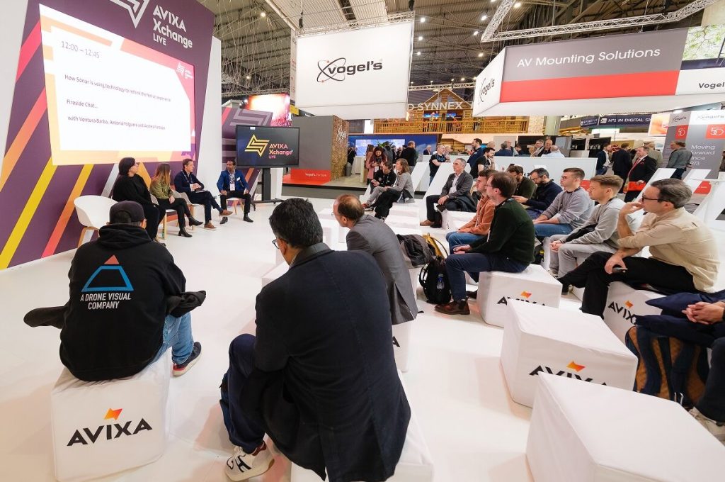 People at a conference sitting on low cubes