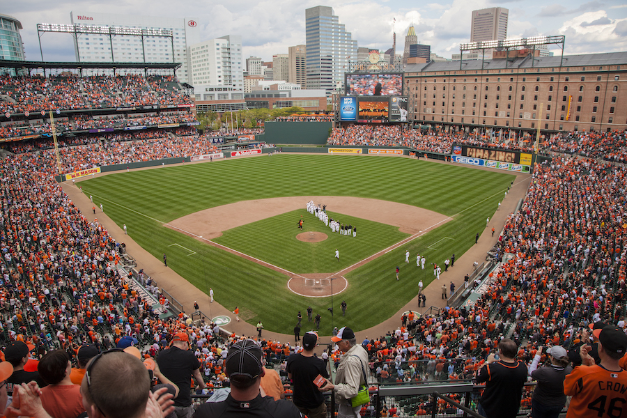 An aerial view of fans filling the stadium at a baseball game held at Camden Yards in Baltimore, a sporting event host city with a legendary baseball legacy.