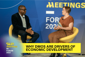 Lorne Edwards (left side) of Visit Phoenix sits on stage next to Angela Tupper (right side) of Skift Meetings. The lower third graphic reads: Why DMOs Are Drivers of Economic Development