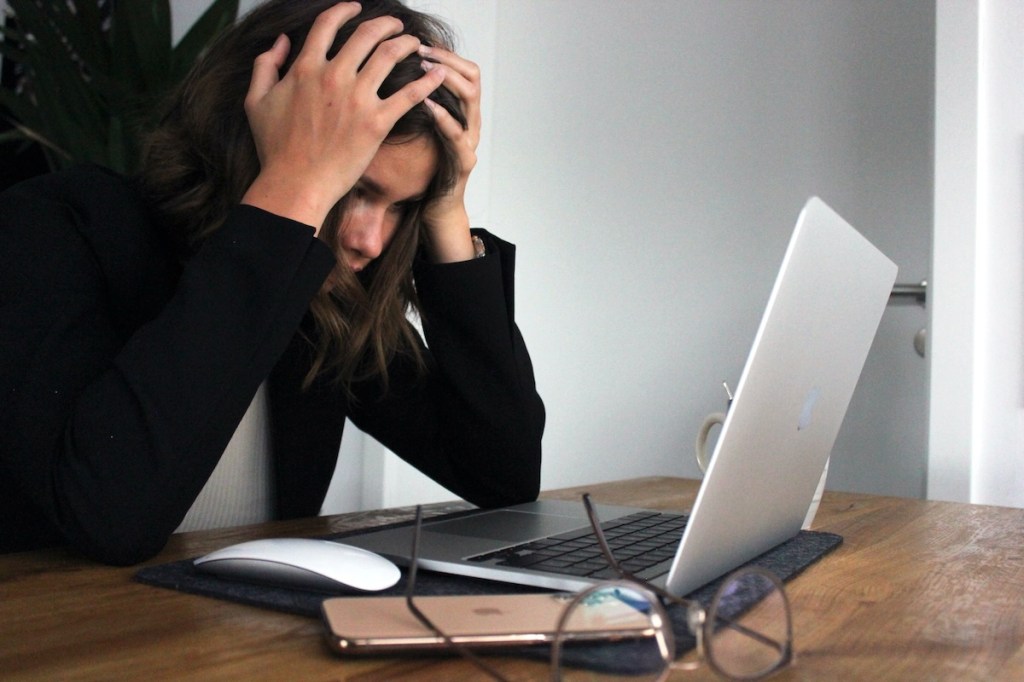 Business woman who is stressed and frustrated staring at a laptop screen