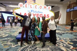 Crowd taking a fun photo in front of a replica of the Las Vegas sign at IMEX America 2023