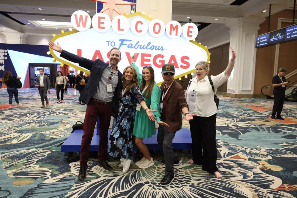 Crowd taking a fun photo in front of a replica of the Las Vegas sign at IMEX America 2023