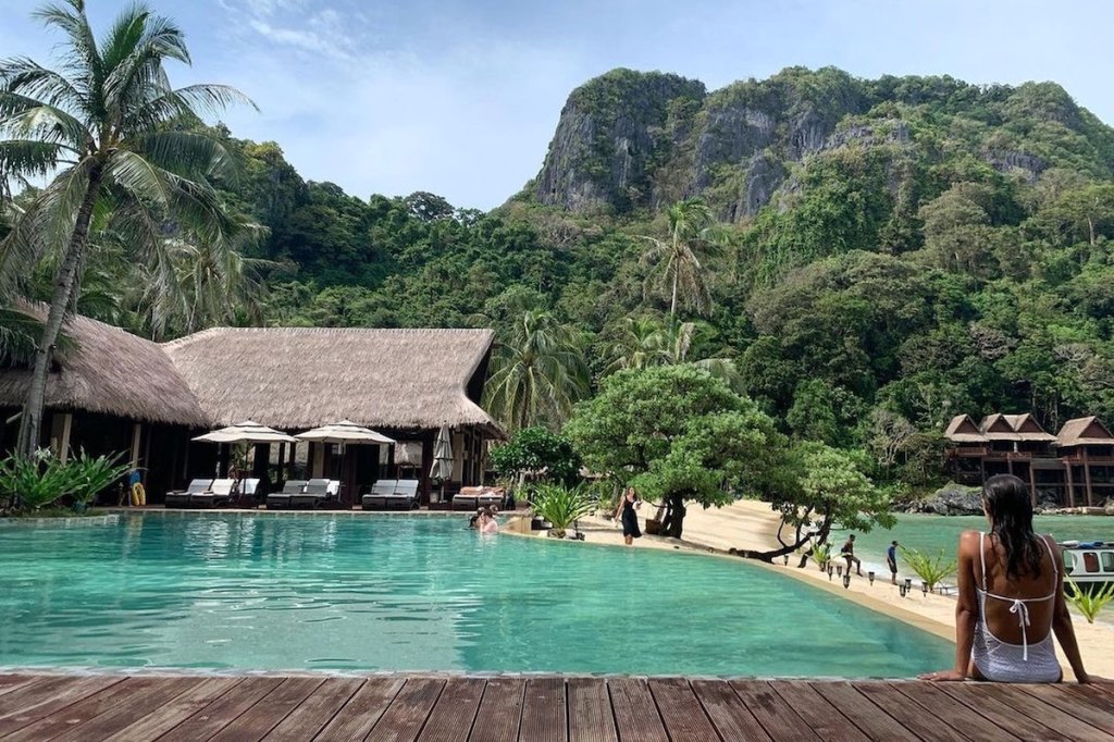 Woman incentive attendee enjoying a relaxing moment at an idilic location with an infinity pool