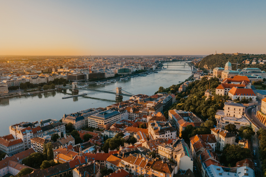 An aerial view of Budapest overlooking the Danube river in the warm glow of the golden hour. It's a city where cultural experiences are waiting to be discovered.