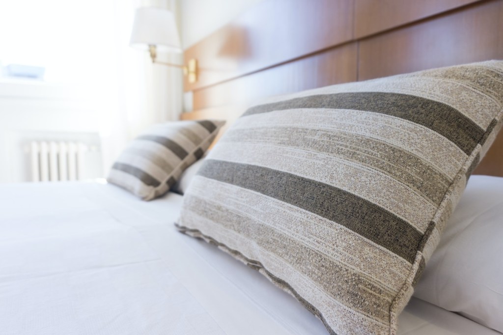 Neat upscale hotel bed with two gray pillows