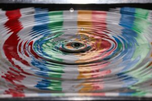 Time lapse photography of water drop causing ripples with a colorful reflection