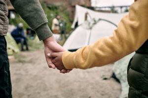 Holding hands outside migrant camp