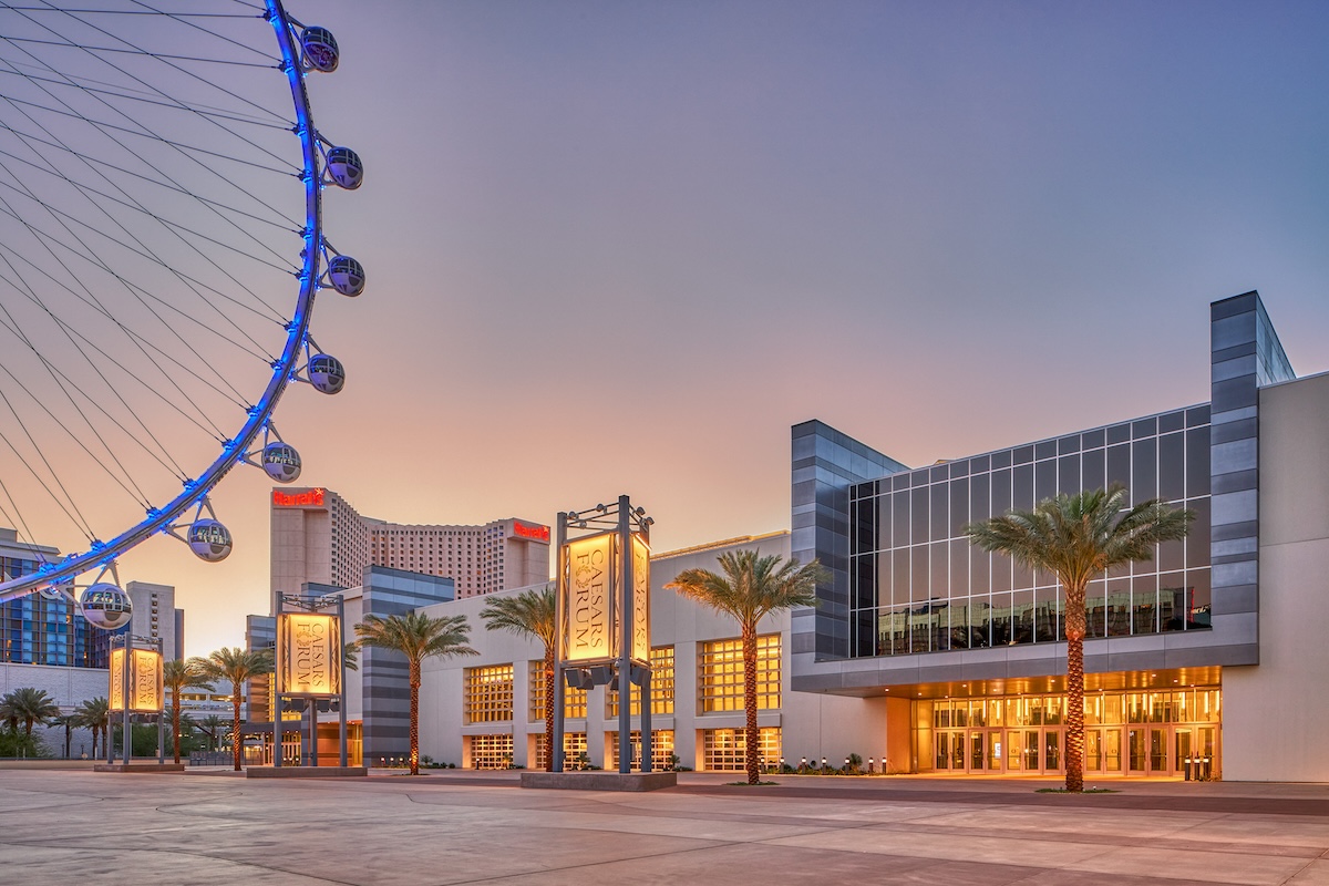 An exterior shot of CAESAR FORUm, a new conference center in Las Vegas, with the High Roller observation wheel visible on the left-hand side and a renovated Harrah's Las Vegas in the background.