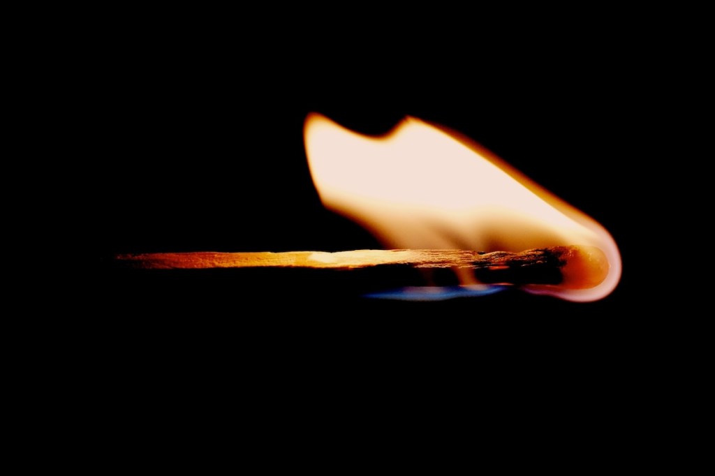 Lit matchstick on a black background