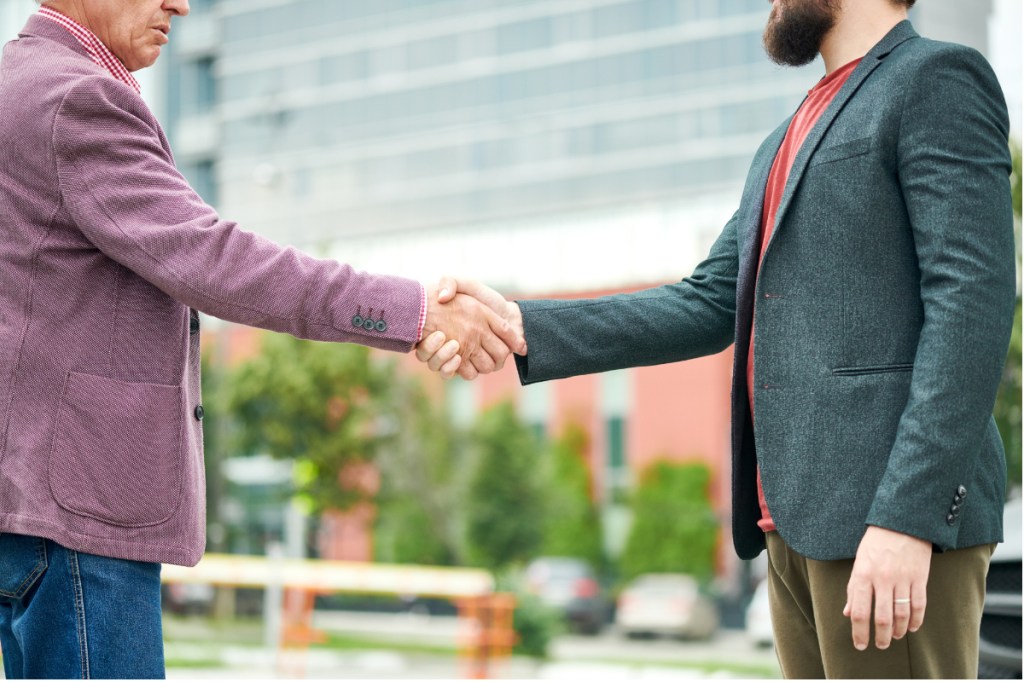 Two men shaking hands outside a convention