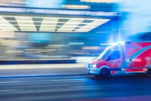 Blurred night-time image of ambulance driving through a city