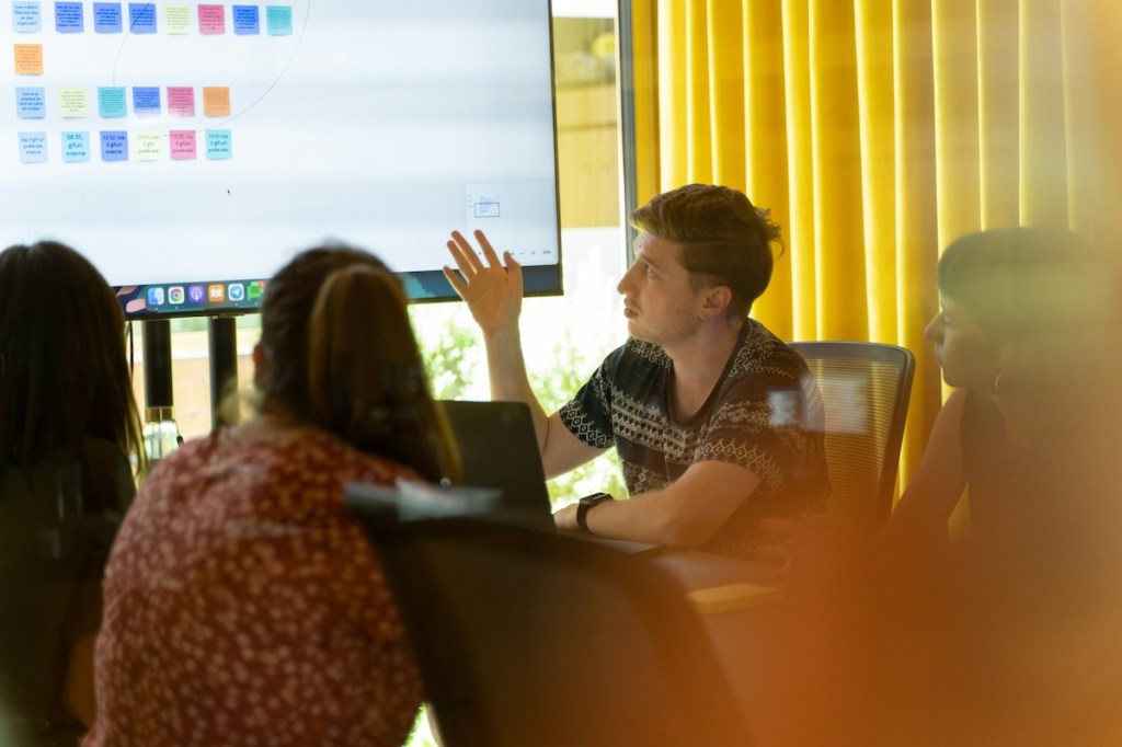 Colleagues having a meeting and looking at a TV monitor