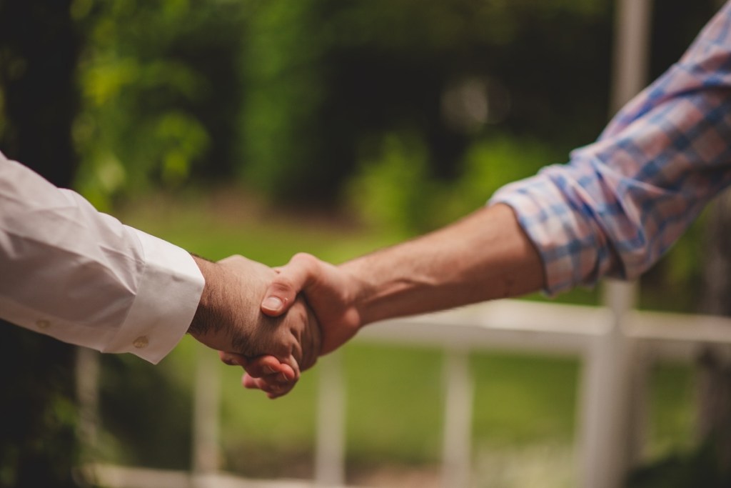 Two men in shirts shaking hands