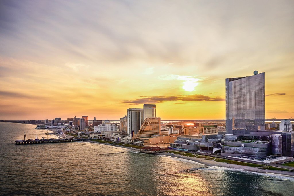 A skyline view of Atlantic City with the yellow glow of the sun setting in the background.