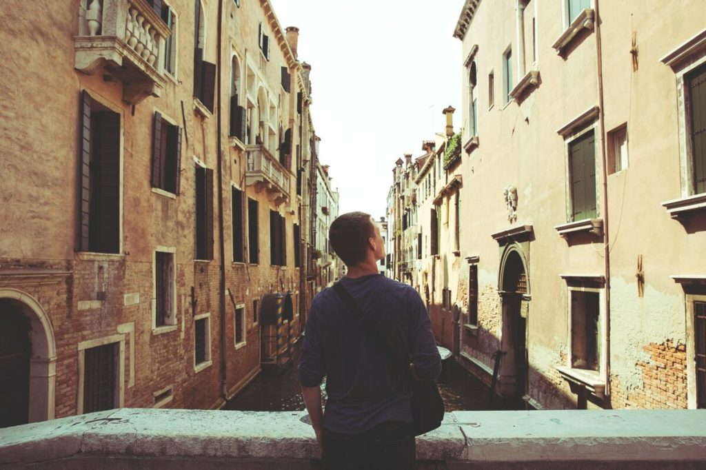 Person looking inquisitively at buildings.