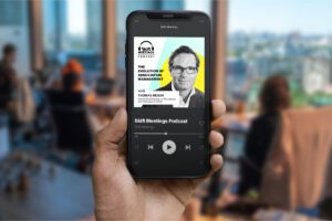 Person holding a smartphone with a podcast app open on the Skift Meetings Podcast featuring Thomas Reiser