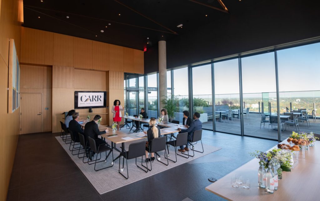 People gathering in a glass enclosed event space