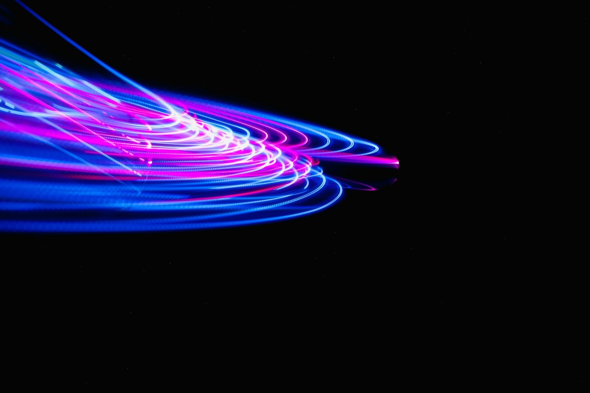 A blurry photo of blue and pink lights on a black background