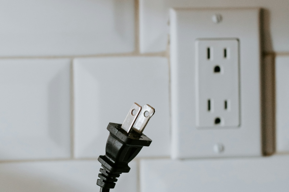 Black power plug out of white socket