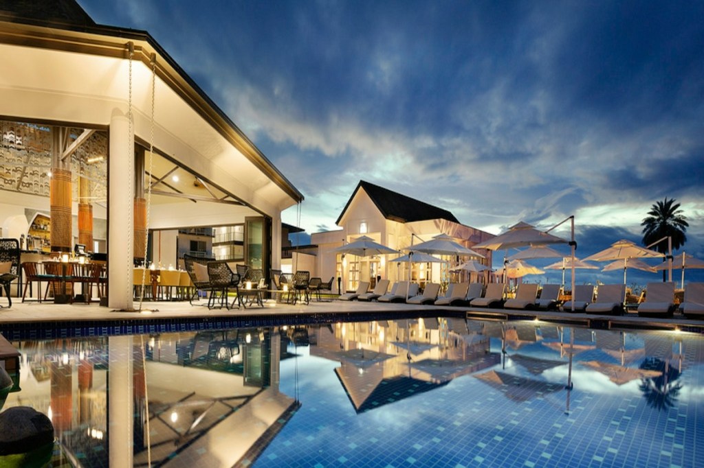 Blue outdoor hotel pool at sunset