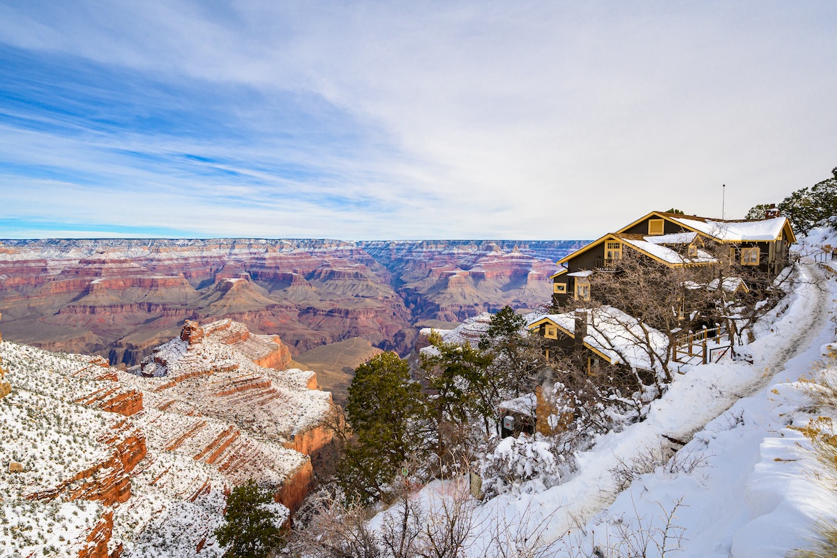 An aerial view of Grand Canyon National Park with a light dusting of snow. A unique meeting venue covers the cliff edge on the right-hand side of the image.
