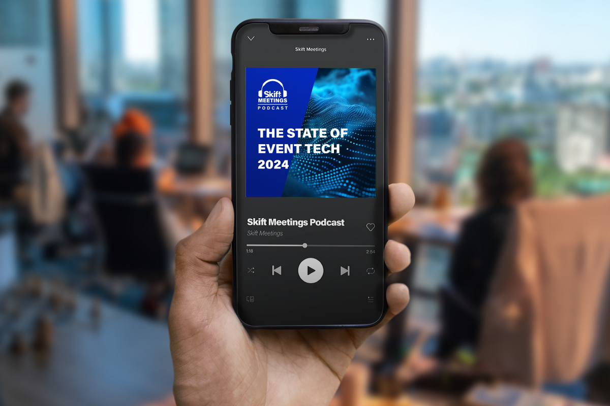 Man holding a smartphone playing the Skift Meetings Podcast - The State of Event Tech 2024