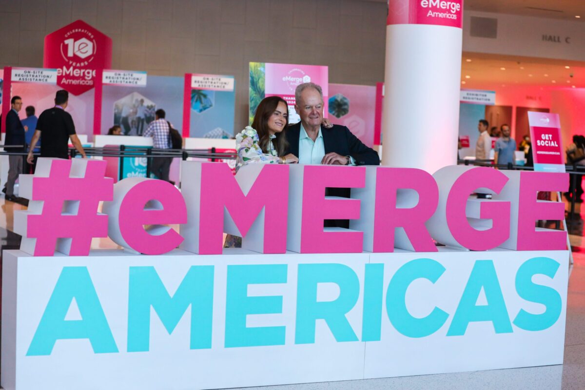 Melissa and Manny Medina in front of an eMerge Americas sign at eMerge Americas 2024