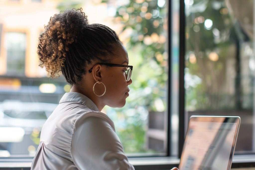 woman sitting a laptop surfing the web in a work setting