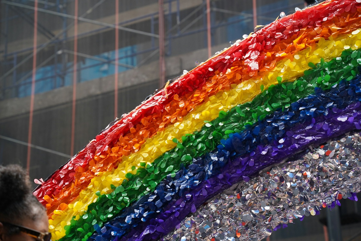 Man standing in front of a rainbow sculpture