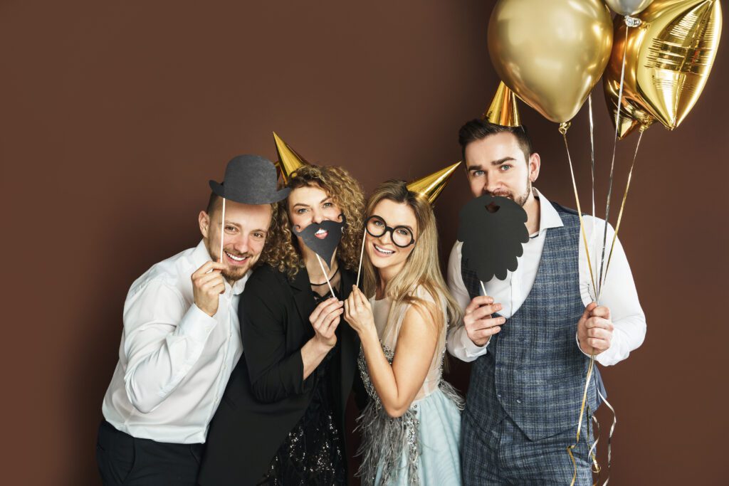 Happy people with photo props celebrating and posing at an event