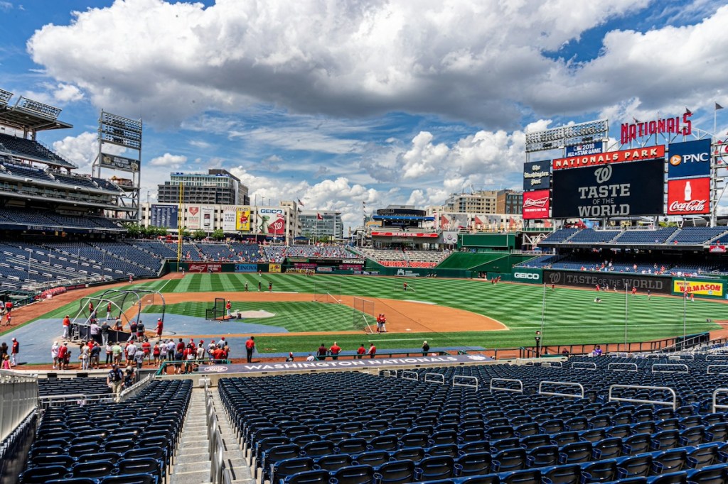 Baseball ground with a few people on the field on a sunny day