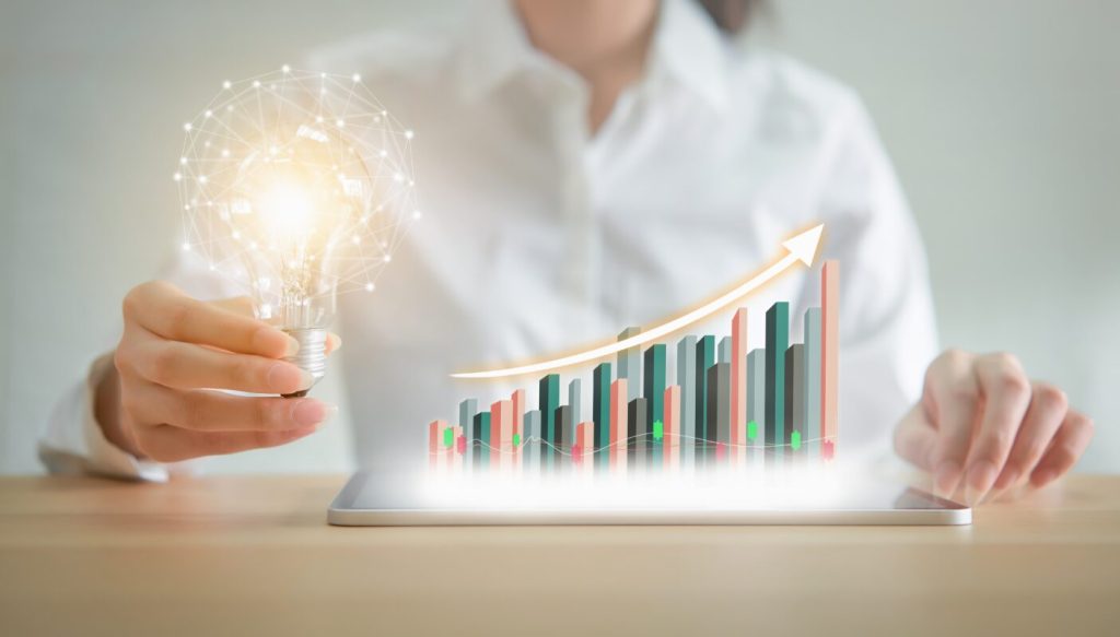 Businesswoman holding a lightbulb depicting rising meeting costs