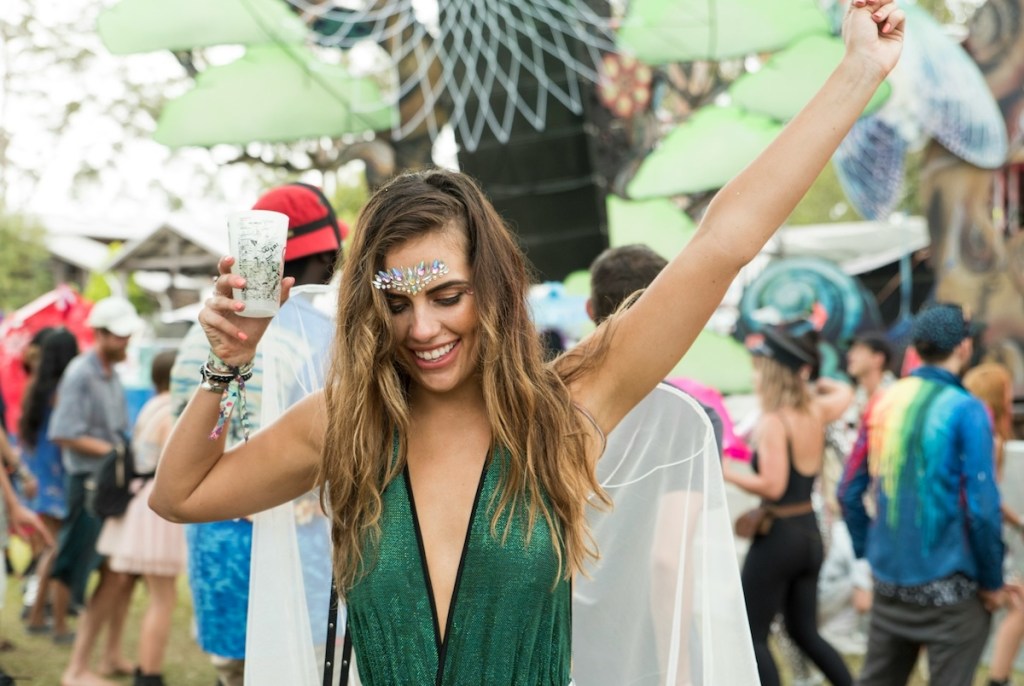 Woman dancing and raising her hand at outdoor music festival in Australia