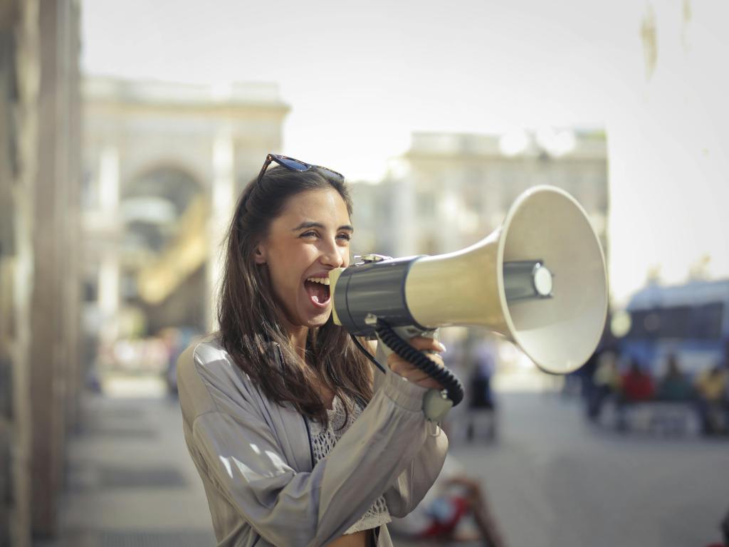 a girl with a megaphone depicting event promotion