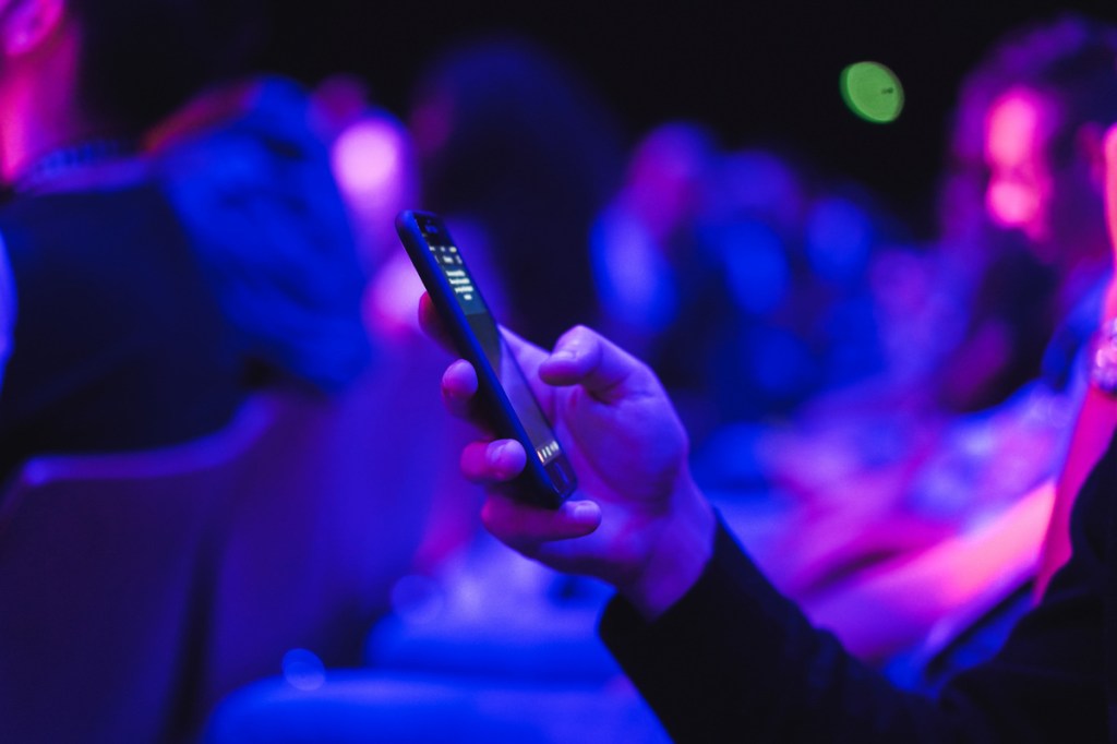 Young man using mobile phone at technology meeting event