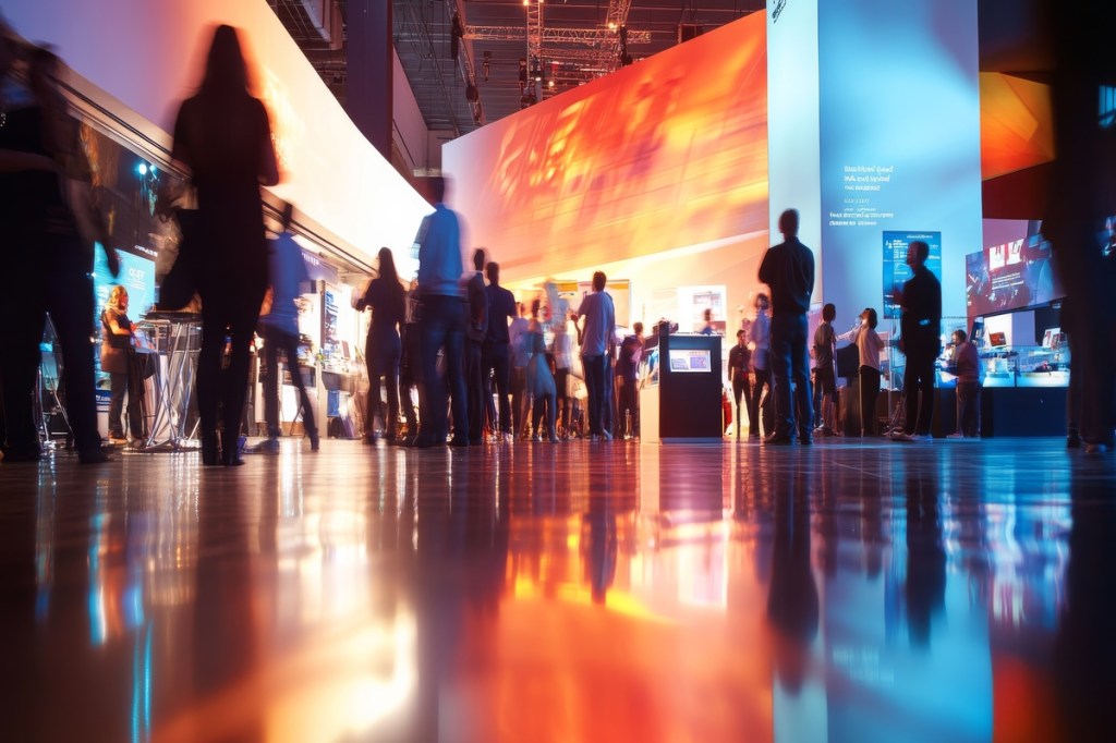 attendees engage with various exhibits showcasing innovative technology and interactive displays in a lively exhibition setting