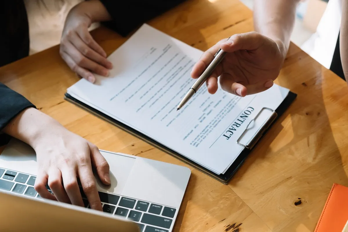 Businesspeople's hands on top of a contract