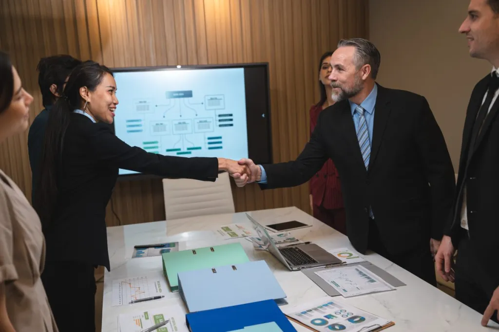 Business people shake hands as they close a deal.